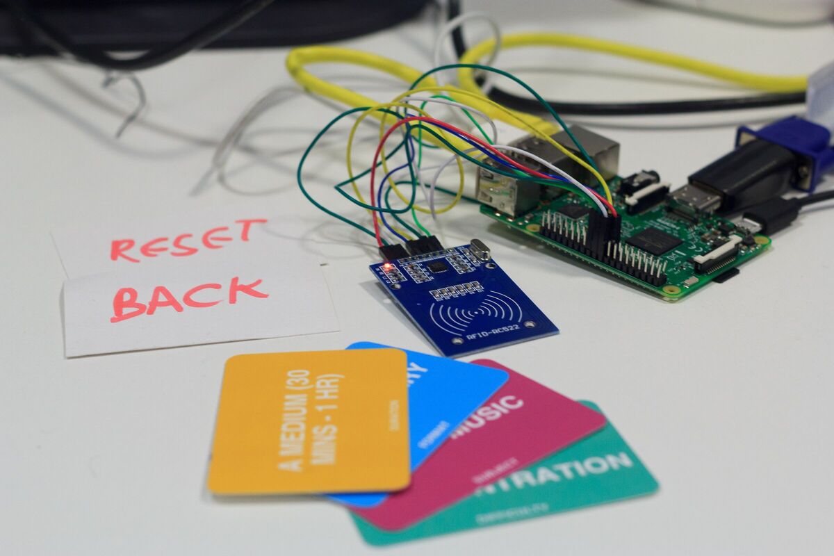 The same three cards in front of an RFID reader and raspberry pi on a table