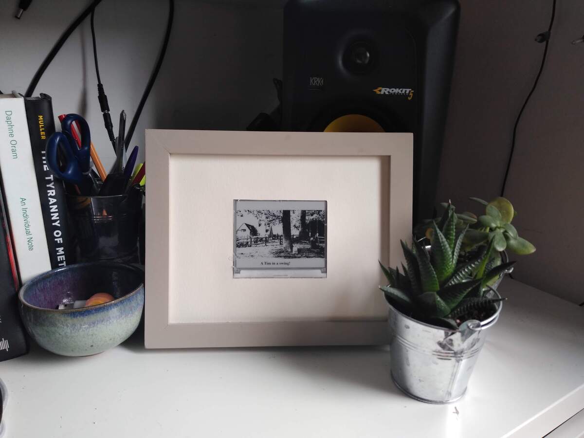 Marco – an e-ink screen in a photo frame, on a shelf.